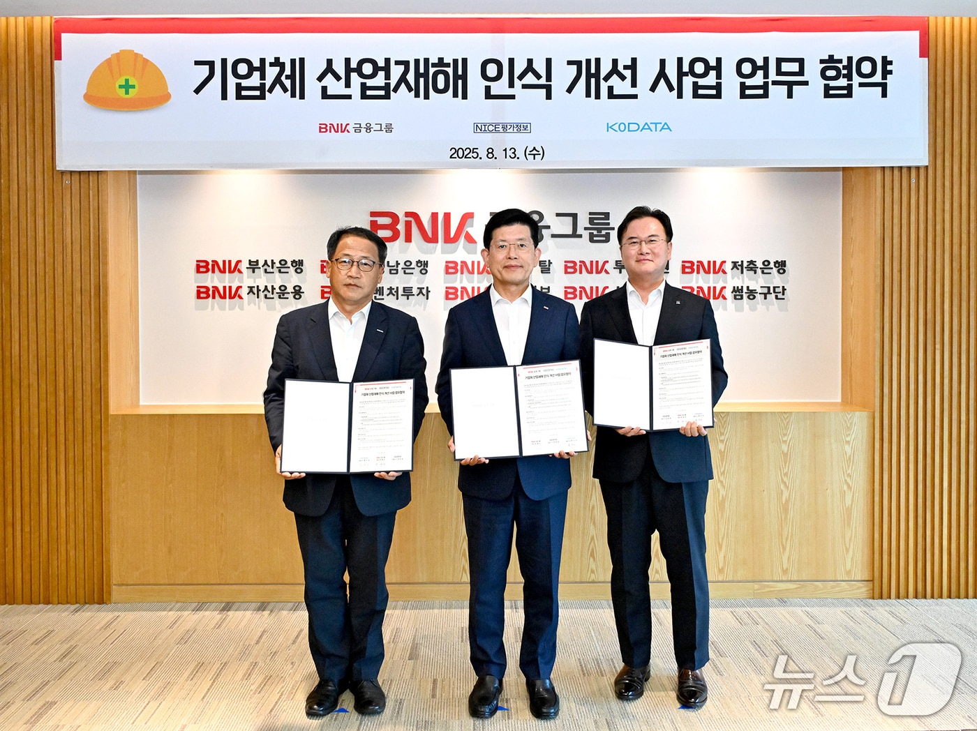 13일 BNK금융그룹에서 열린 기업체 산업재해 인식 개선 사업 업무 협약식에서 홍두선 한국평가데이터 대표(왼쪽부터), 빈대인 BNK금융그룹 회장, 김종윤 NICE평가정보 대표가 협약서를 들어 보이고 있다. (BNK금융그룹 제공. 재판매 및 DB 금지)