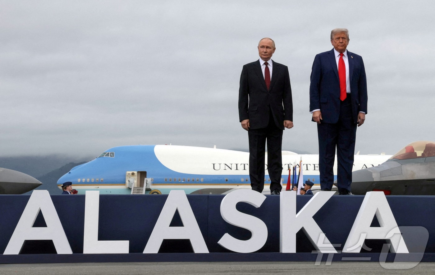 도널드 트럼프 미국 대통령과 블라디미르 푸틴 러시아 대통령이 15일(현지시간) 미국 알래스카 앵커리지 엘멘도르프-리처드슨 합동 기지에서 열린 회담에 참석하기 위해 도착한 후 활주로 연단에서 포즈를 취하고 있다. 2025.8.15 ⓒ 로이터=뉴스1