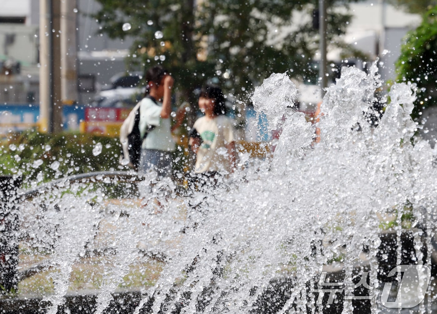 경기 오산시 수청공원에서 시민들이 시원하게 쏟아지는 폭포 앞으로 지나가고 있다. 2025.8.18/뉴스1 ⓒ News1 김영운 기자