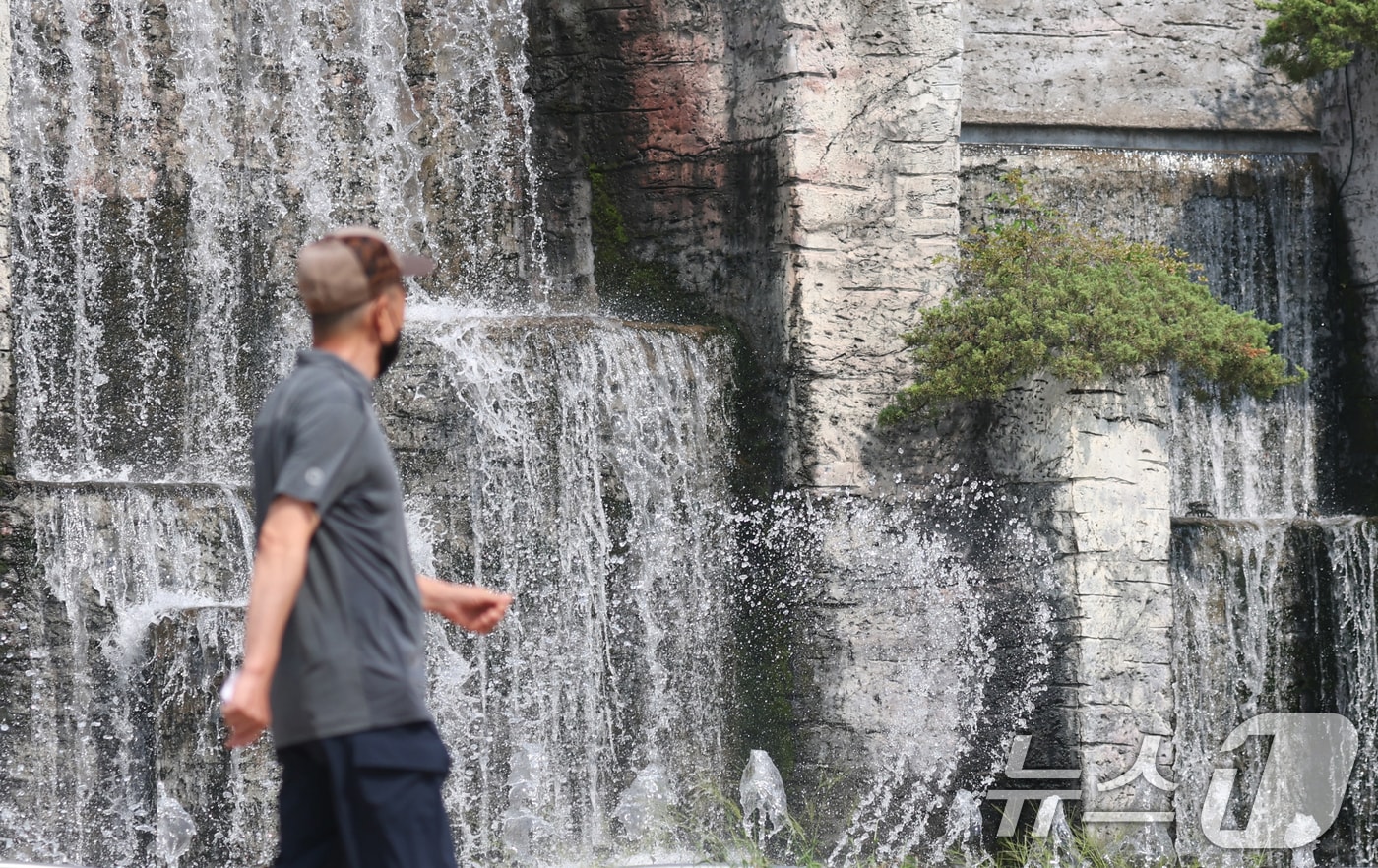 전국 대부분 지역에 폭염 경보나 주의보가 이어지고 있는 가운데 18일 오후 경기 오산시 수청공원에서 시민들이 시원하게 쏟아지는 폭포 앞으로 지나가고 있다. 2025.8.18/뉴스1 ⓒ News1 김영운 기자