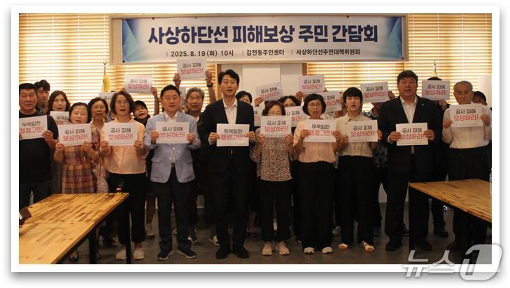 ‘사상~하단선 건설사업 15번째 땅꺼짐(씽크홀) 사고’ 주민 간담회에 참석한 전원석 시의원과 주민들이 공사 피해 보상을 촉구하는 손팻말을 들고 있다.(부산시의회 제공. 재판매 및 DB금지)