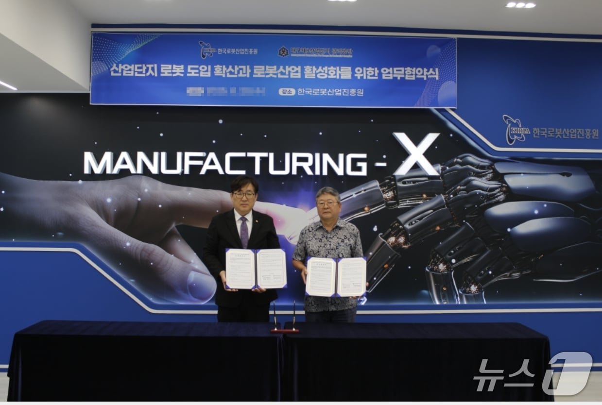 류지호 한국로봇산업진흥원장 직무대행(왼쪽)과 홍종윤 대구 제3산업단지관리공단 이사장이 산업단지 입주기업의 로봇 도입 확산을 위한 업무협약을 체결한 뒤 협약서를 펼쳐 보이고 있다.(로봇산업진흥원 제공. 재판매 및 DB 금지)