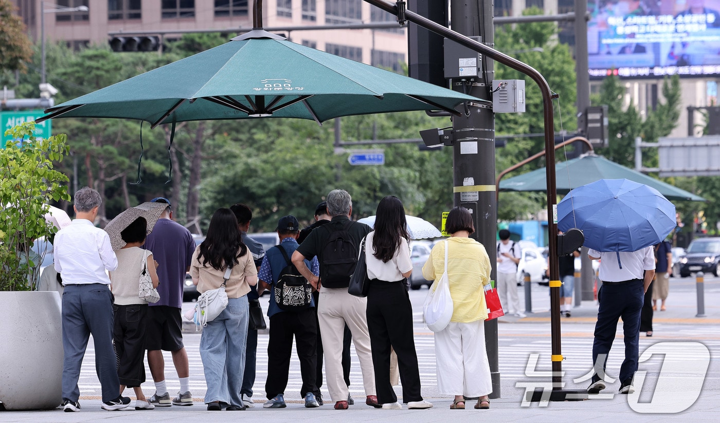 절기상 ‘처서’가 이틀 앞으로 다가왔지만 여전히 찜통 더위가 이어진 21일 오후 서울 광화문네거리에서 시민들이 횡단보도 앞 그늘막 아래 모여 신호를 기다리고 있다. 폭염특보가 해소되기는커녕 폭염경보로 격상되는 지역들이 늘면서, 당분간 무더위는 지속될 전망이다. 2025.8.21/뉴스1 ⓒ News1 박지혜 기자