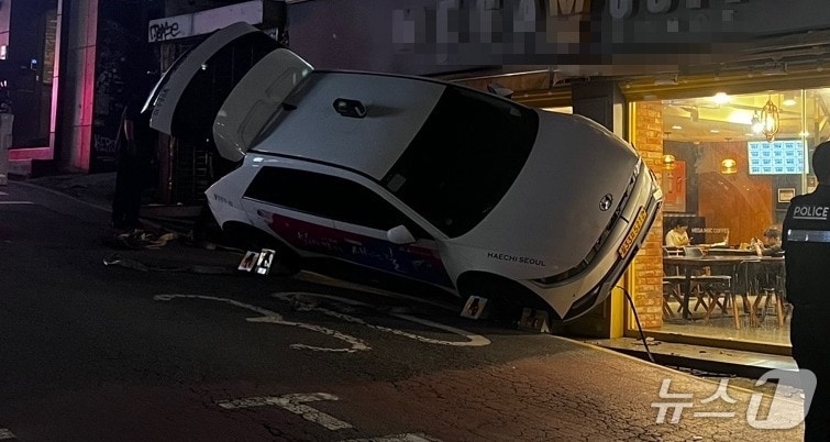 21일 오후 6시 47분쯤 서울 마포구 한 상점가에 돌진한 택시가 비스듬히 멈춰 서있다.(독자제공)