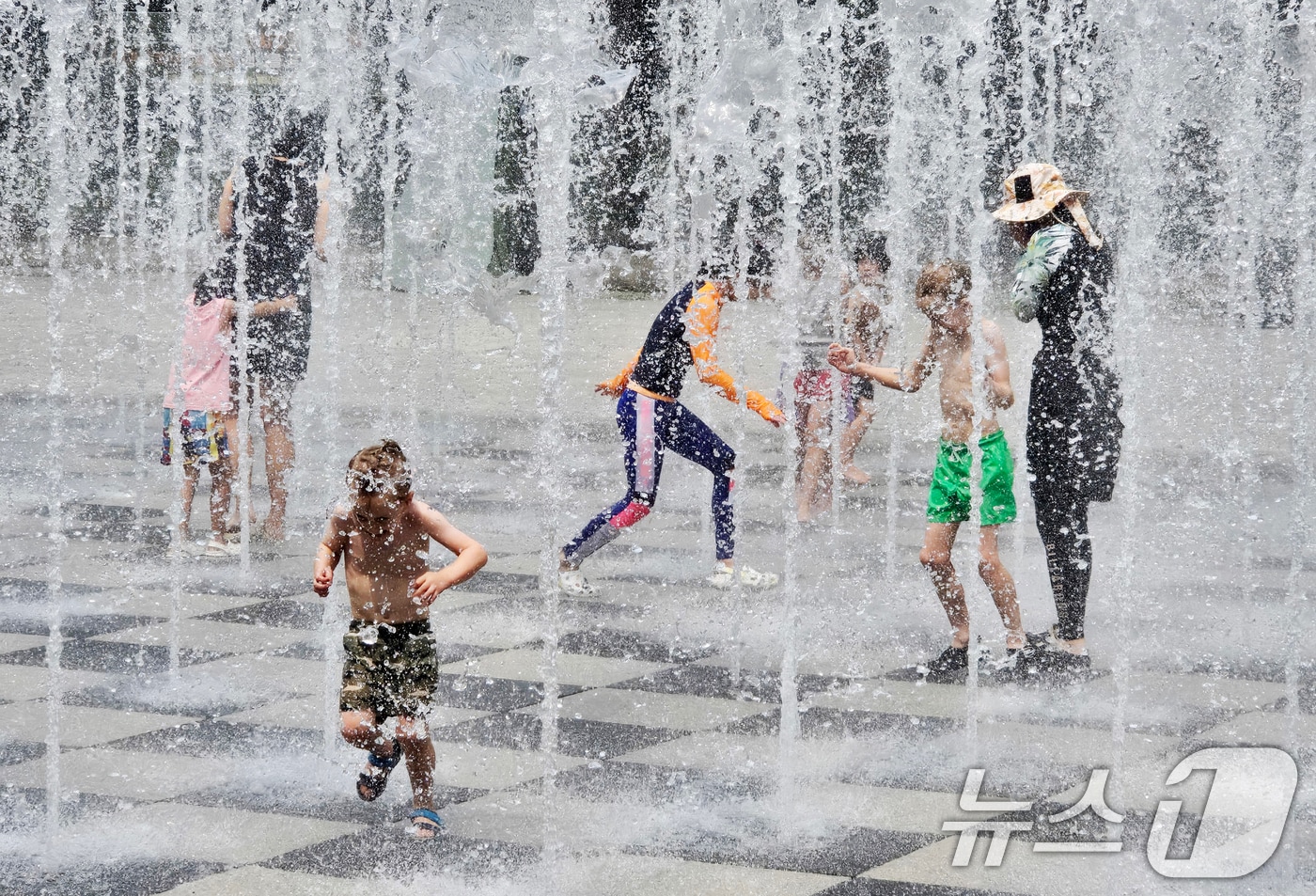 서울 성동구 서울숲에서 시민들이 바닥 분수에서 나오는 물줄기를 맞으며 더위를 식히고 있다./뉴스1 ⓒ News1 황덕현 기후환경전문기자