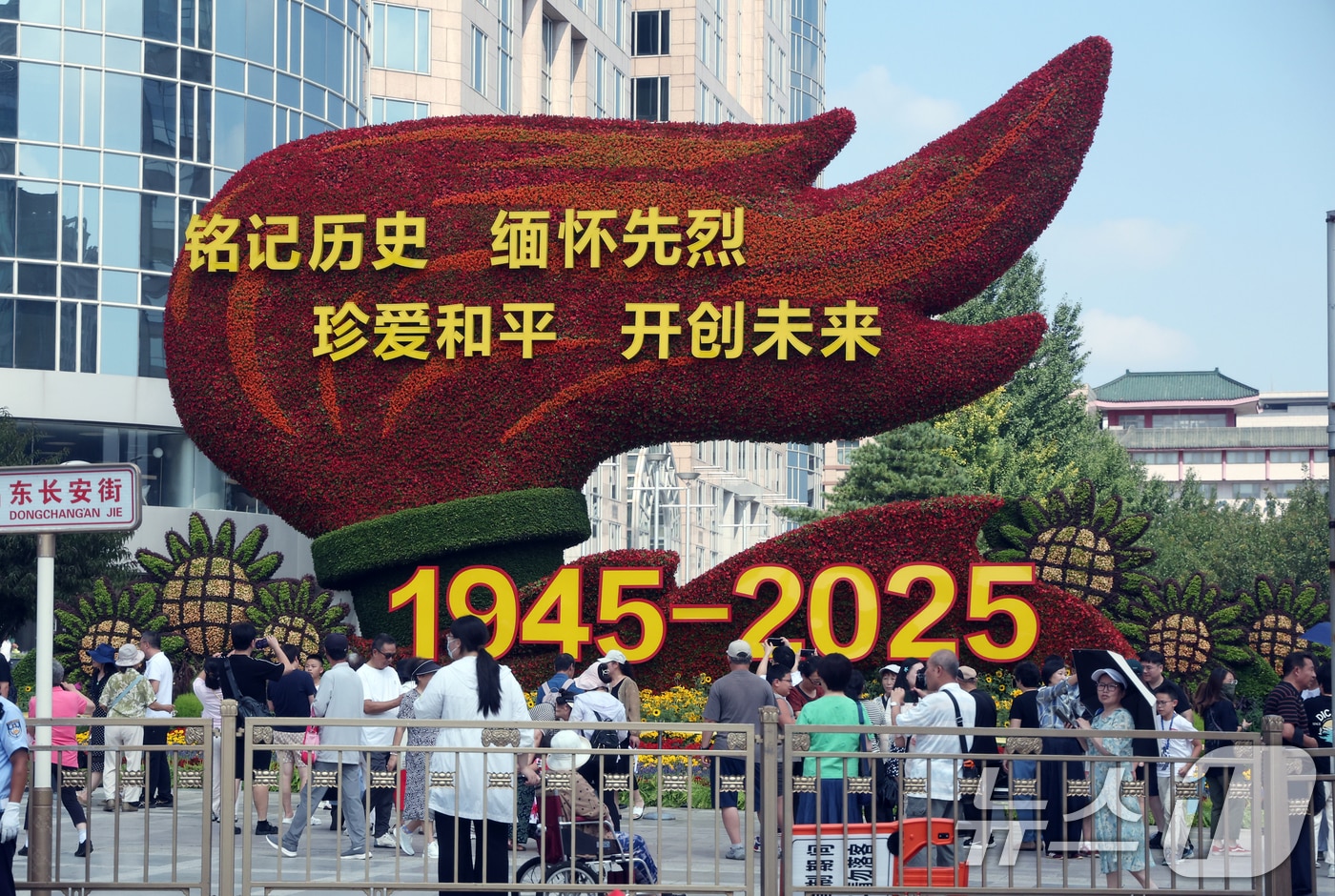 중국의 항일전쟁 및 세계 반파시스트 전쟁(제2차 세계대전) 승리 80주년(전승절) 기념 열병식을 사흘 앞둔 31일 중국 베이징 천안문 인근 거리에 설치된 꽃 조형물 앞에서 행인들이 기념 사진을 찍고 있다. 2025.8.31/뉴스1 ⓒ News1 박정호 기자