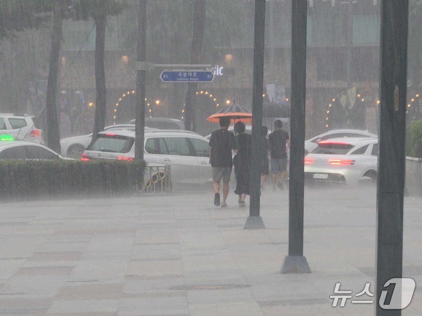 광주에 시간당 30㎜의 소나기가 쏟아진 31일 시민들이 우산을 쓰고 빗길을 걸어가고 있다. 2025.8.31/뉴스1