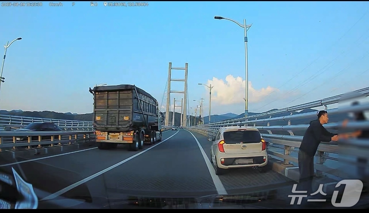 마산소방서 이보검 소방사가 지난 29일 오후 마창대교에서 극단적 선택을 하려던 여성을 붙잡고 설득하고 있다.(마산소방서 제공. 재판매 및 DB금지)