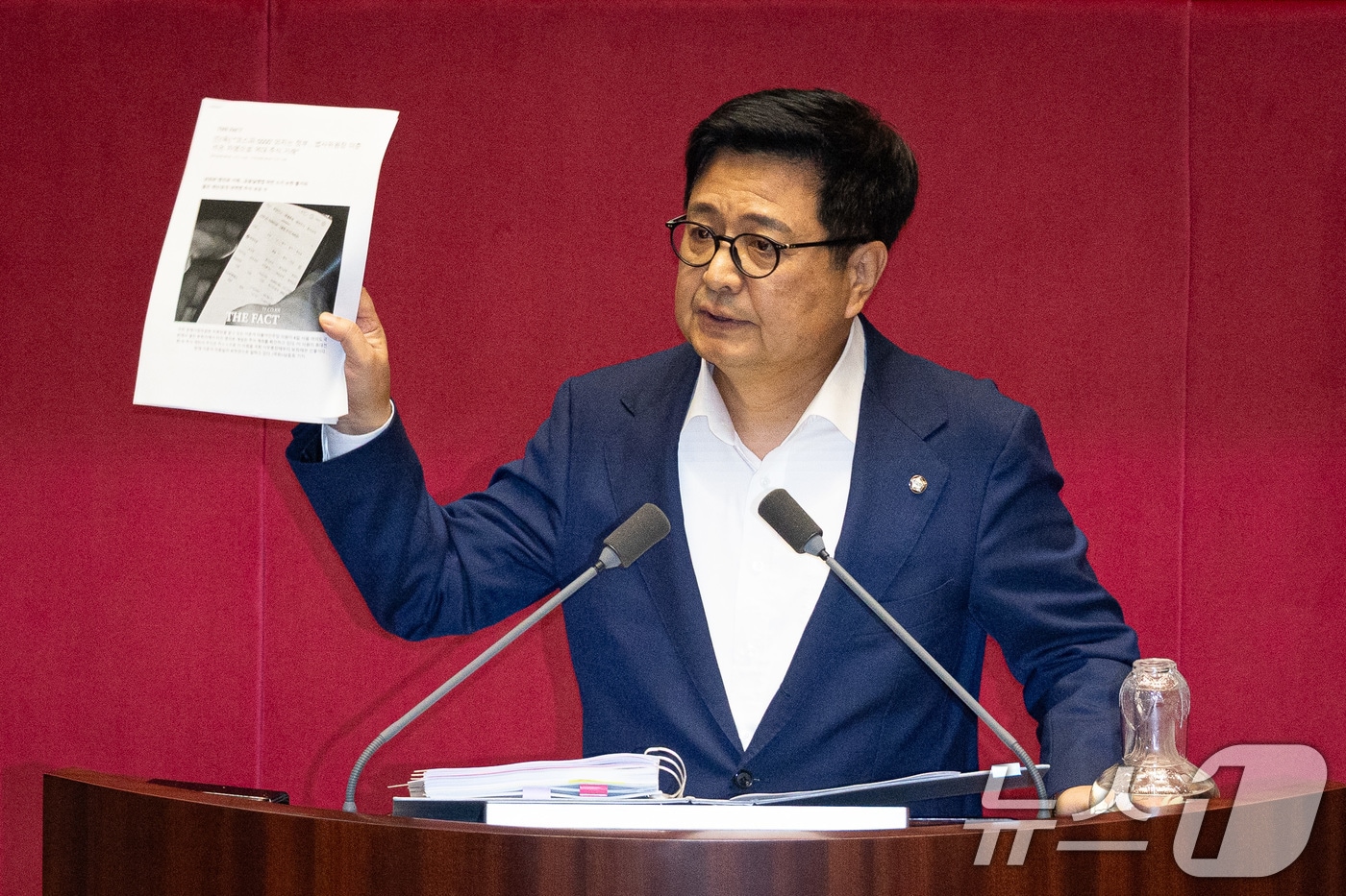 김장겸 국민의힘 의원이 5일 서울 여의도 국회에서 열린 제427회 국회(임시회) 3차 본회의에서 방송문화진흥회법 일부개정법률안(대안)에 대한 무제한토론(필리버스터) 중 이춘석 더불어민주당 의원의 주식차명거래 의혹 보도를 들어보이고 있다. 2025.8.5/뉴스1 ⓒ News1 유승관 기자