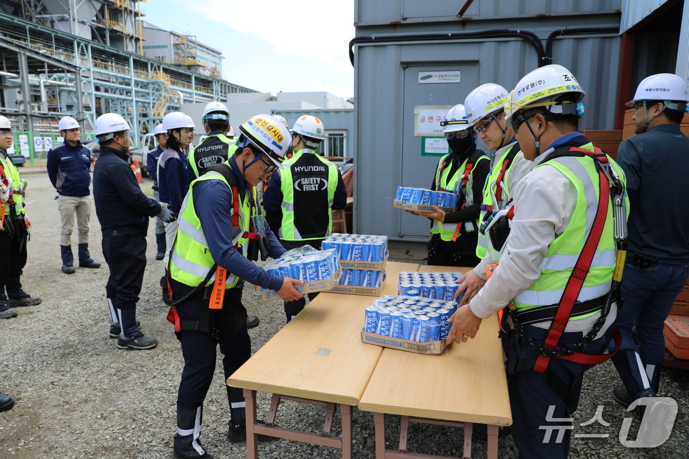 현대로템 관계자들이 수분보충음료를 전달 받고 있는 모습(현대로템 제공)