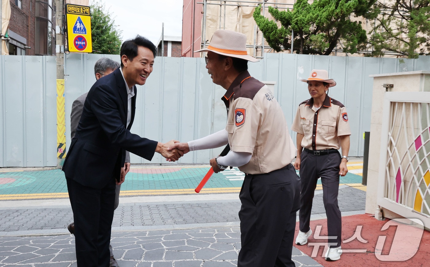 초등학생 등하굣길 안전 관련 현장방문에 나선 오세훈 서울시장이서울 광진구 양남초등학교 찾아 학교 보안관과 인사를 나누고 있다. 2025.9.12 ⓒ 뉴스1 박지혜 기자