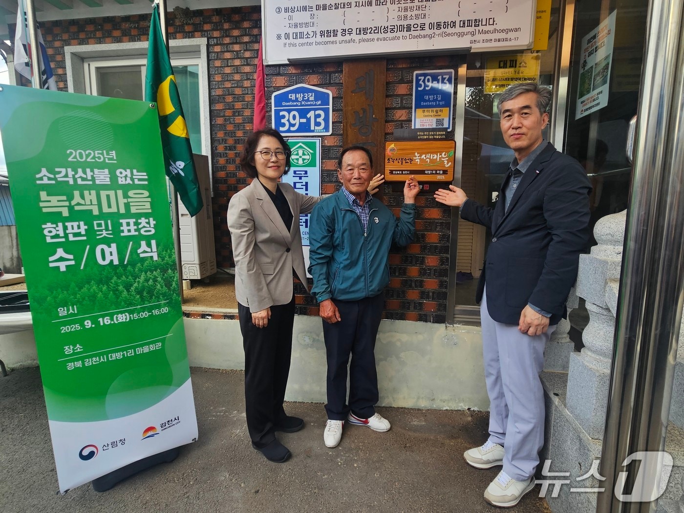 이미라 산림청 차장이 우수 녹색마을 현판을 달고 기념 촬영을 하고 있다. (산림청 제공.재판매 및 DB금지)/뉴스1