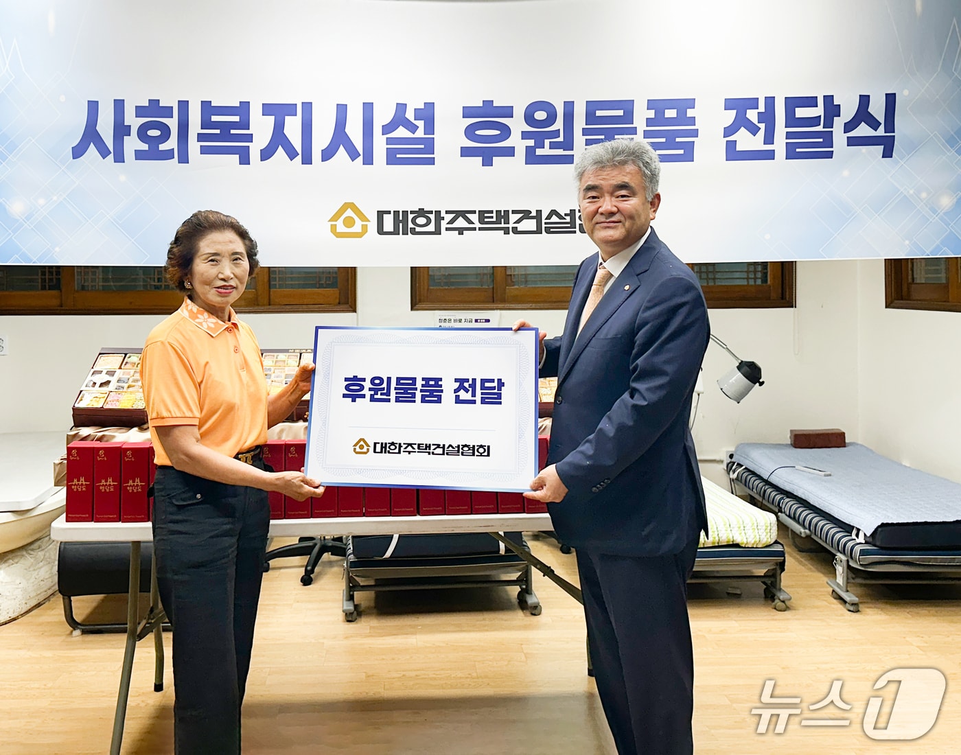 정원주 대한주택건설협회장(오른쪽)이 구립 회현경로당 회장에게 후원 물품을 전달하고 있다./뉴스1 ⓒ News1