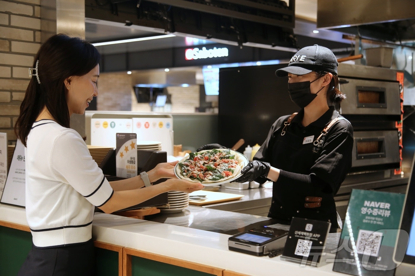 광주신세계 본관 지하1층 입점업체인 바리에에서 직원이 고객에 피자를 전달하고 있다.&#40;광주신세계 제공. 재배포 및 DB 금지&#41;