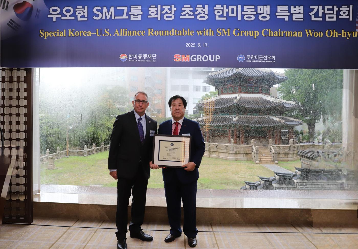 우오현 SM그룹 회장(오른쪽)이 지난 17일 서울 중구 웨스틴조선 서울에서 열린 한미동맹 특별 간담회에서 로버트 에이브럼스 주한미군전우회장(전 한미연합사 사령관)에게 감사패를 받은 뒤 기념촬영을 하고 있다. 감사패에는 한미연합사 사령관을 지낸 4성 장군 4인을 상징하는 별 16개와 사인이 담겼다. (SM그룹 제공)