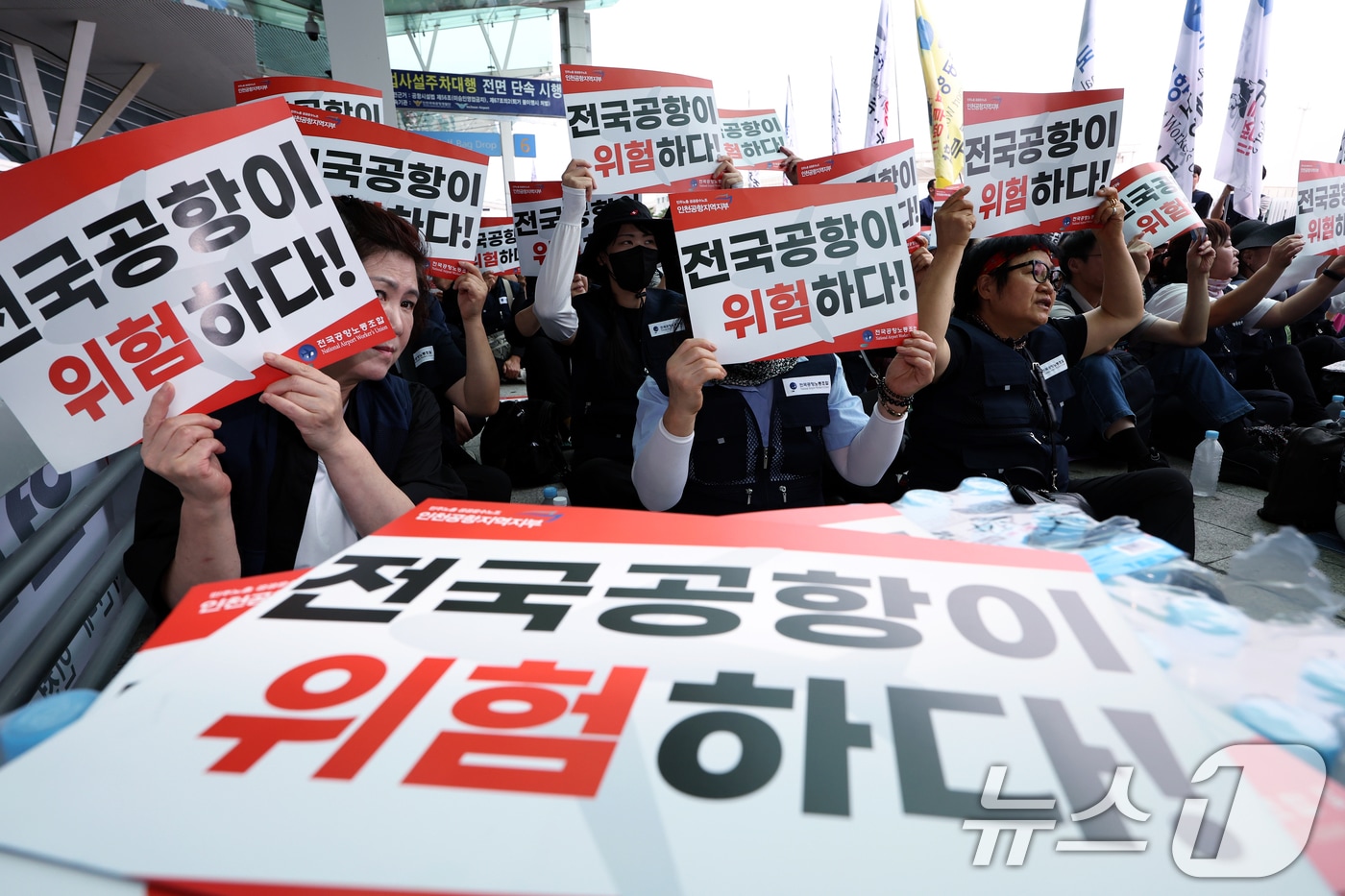 민주노총 전국공공운수노조 인천공항지역지부와 전국공항노동조합 등 전국공항노동자연대 조합원 등이 19일 오전 인천국제공항 2터미널에서 열린 안전한 일터·안전한 공항을 위한 전국공항노동자 총파업 대회에서 구호를 외치고 있다.2025.9.19/뉴스1 ⓒ News1 박정호 기자