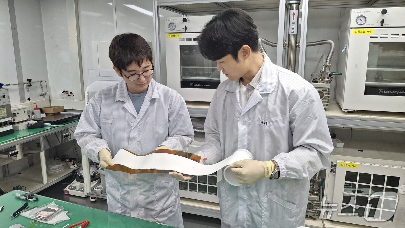 롤 형태로 제조된 대면적 고체전해질막의 전체 품질과 외관 상태를 점검하는 ETRI 연구진&#40;ETRI 제공&#41; /뉴스1