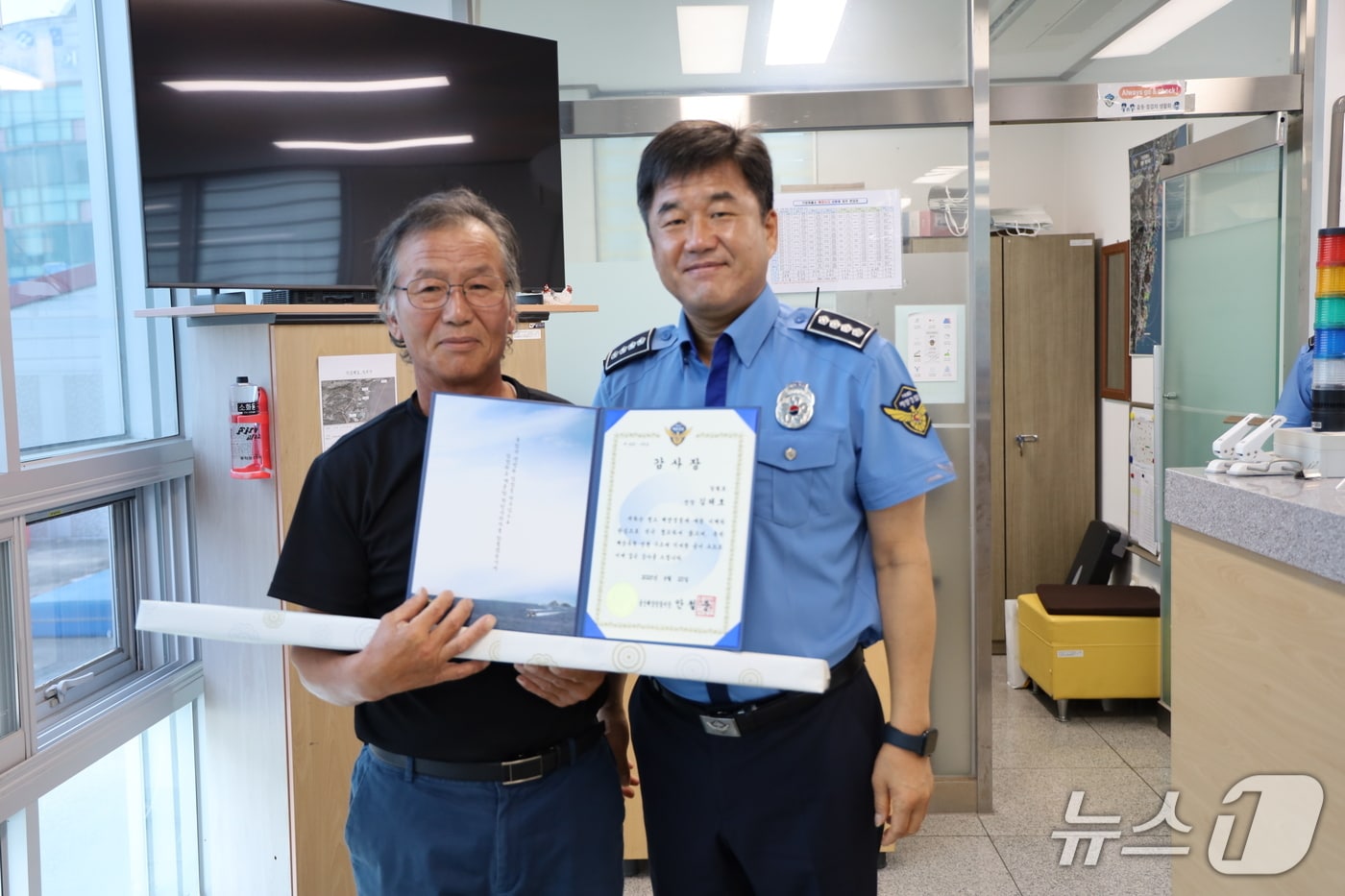 안철준 울산해양경찰서장(오른쪽)이 23일 기장파출소를 찾아 기장 동백항 김태호 선장(왼쪽)에게 감사장을 수여하고 사진을 찍고 있다.(울산해경 제공. 재판매 및 DB금지)/뉴스1