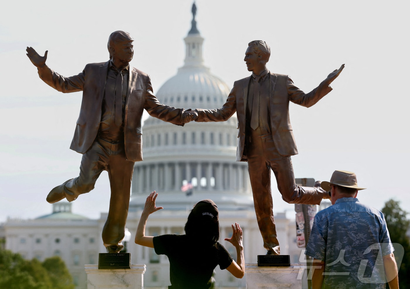 미국 워싱턴DC 연방의회 의사당 앞 내셔널 몰에 설치된 동상 앞에서 방문객들이 도널드 트럼프 미국 대통령과 제프리 엡스타인의 모습을 묘사한 조각상을 올려다보고 있다. 2025.09.23. ⓒ 로이터=뉴스1 ⓒ News1 윤다정 기자