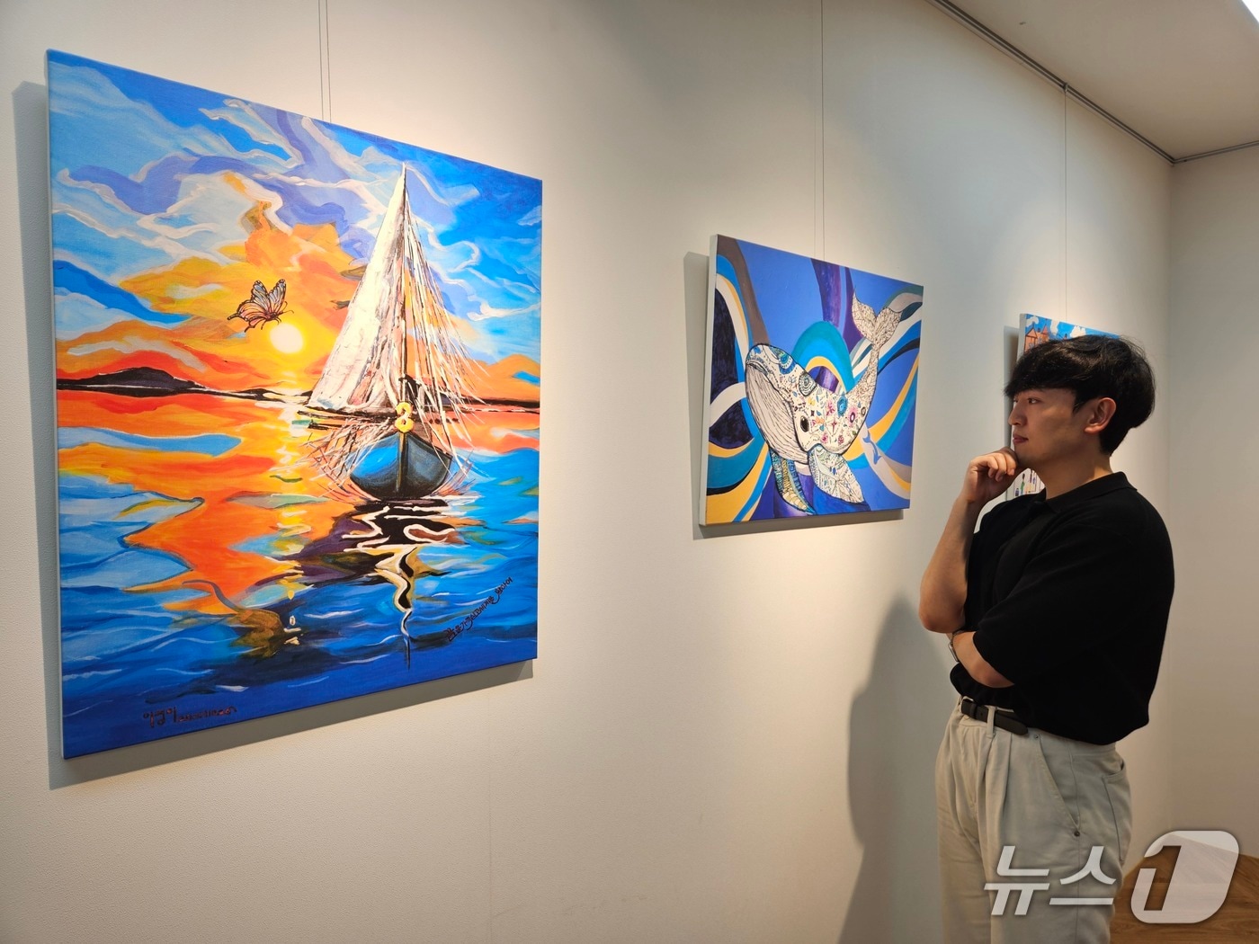 현대제철 직원이 ㈜올모용인 사업장에 걸린 소속 발달장애인 작가들의 작품을 감상하고 있다. (현대제철 제공) 