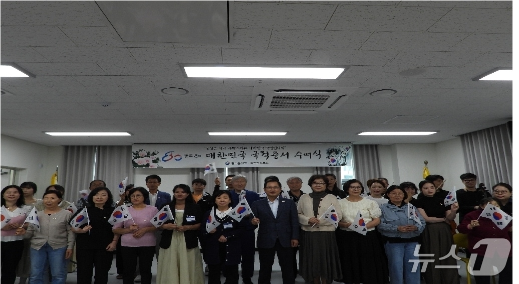 법무부 청주출입국·외국인사무소 관계자 등이 25일 사무소 대회의실에서 열린 '국적증서 수여식'을 마치고 기념 촬영을 하고 있다.(법무부 청주출입국·외국인사무소 제공. 재판매 및 DB금지)/뉴스1