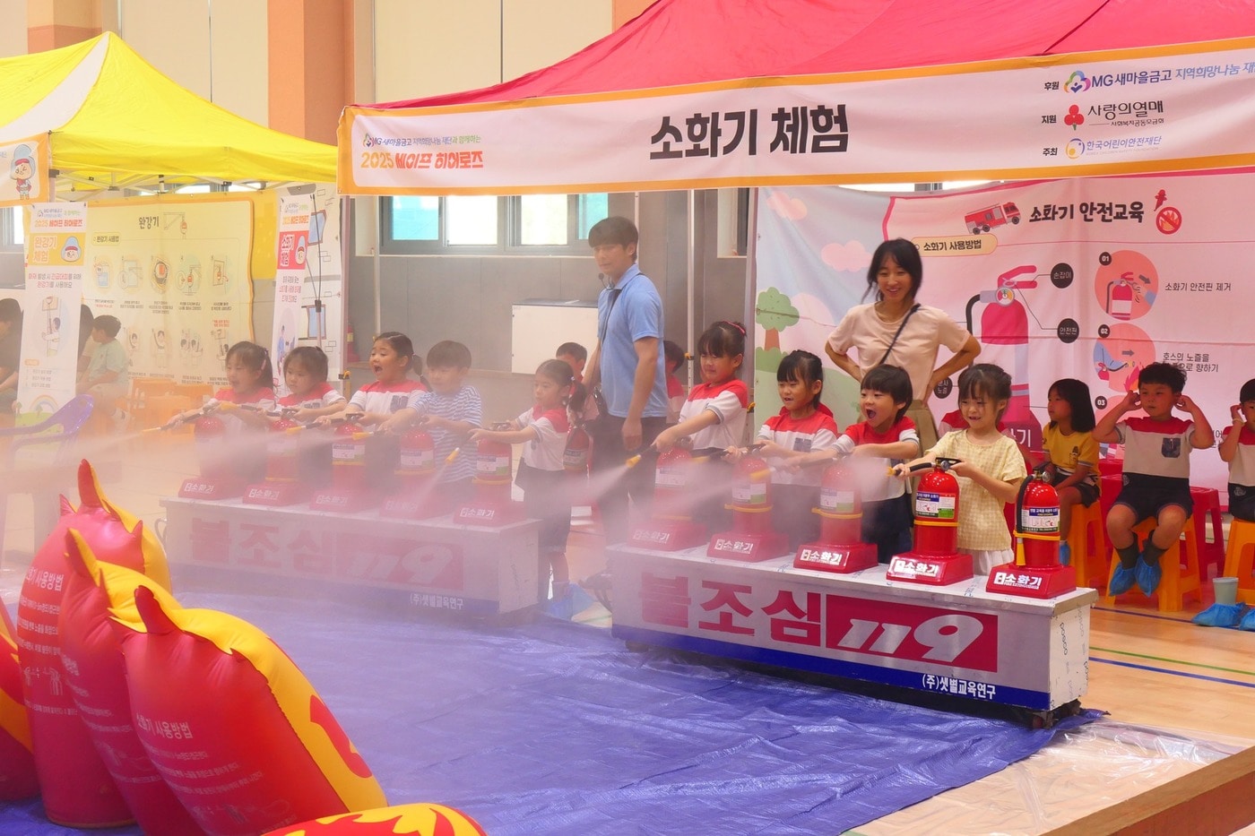 강원지역 학교 교내 강당에서 열린 안전교육 체험 활동인 '세이프 히어로즈'에 참여한 어린이와 아동들이 소화기를 분사하며 안전 체험을 하고 있다.(새마을금고중앙회 제공)