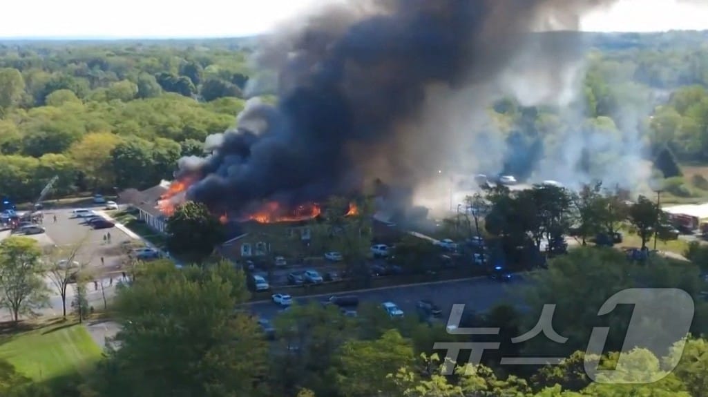 28일(현지시간) 미시간주 그랜드블랑 타운십에 위치한 예수 그리스도 후기 성도 교회에서 발생한 화재 현장을 드론으로 촬영한 영상의 한 장면. 해당 영상은 소셜미디어 X에서 Julie J(@MALKOWSKI6APRIL)가 공유한 것으로, 차량 돌진과 총격 사건으로 교회 건물에서 연기가 치솟는 모습이 담겨 있다. 2025.9.28ⓒ AFP=뉴스1