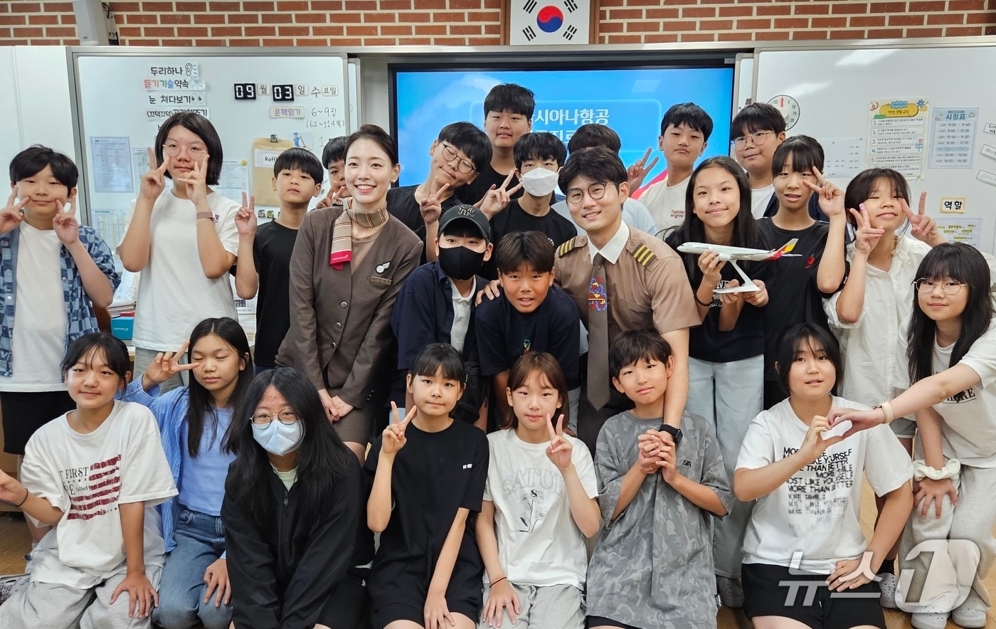 3일 서울 공진초등학교에서 열린 아시아나항공 직업 특강에서 이동준 부기장(오른쪽)과 이민정 부사무장(왼쪽)이 강연을 마친 뒤 초등학생들과 기념사진을 촬영했다(아시아나항공 제공). 2025.09.03.