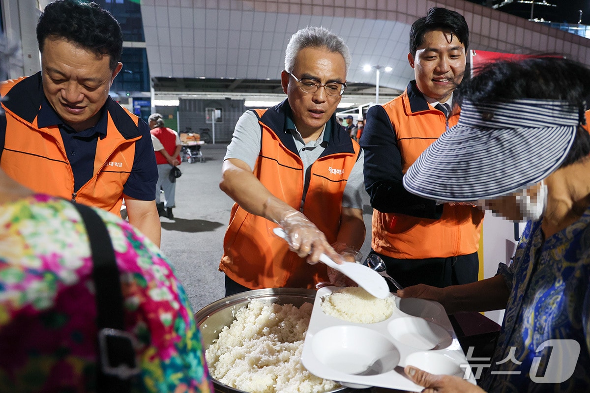 목원대 이희학 총장(가운데)이 노숙인에게 밥을 배식하고 있다. (목원대 제공.재판매 및 DB 금지)/뉴스1