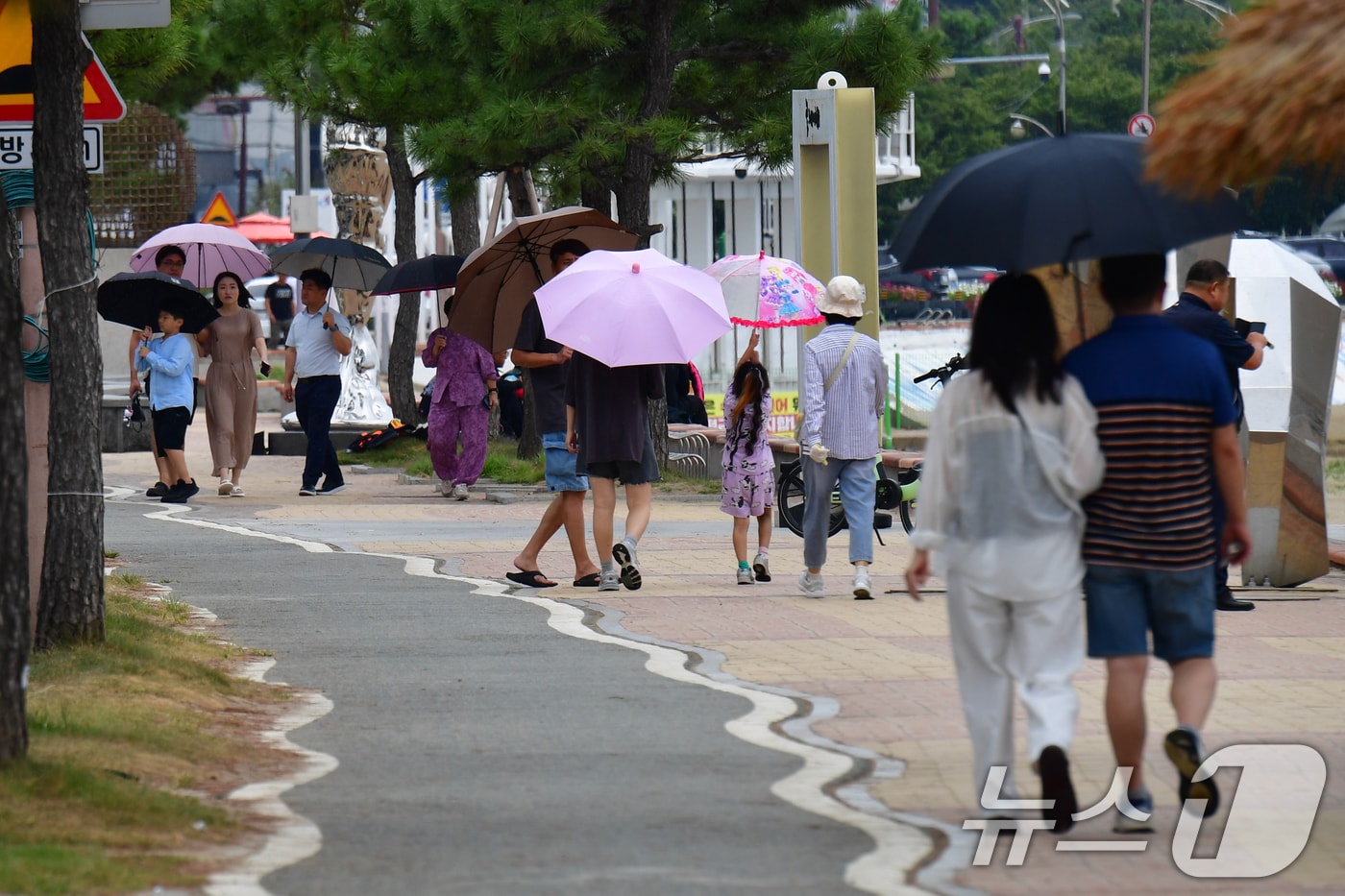 7일 경북 포항시 북구 영일대해수욕장에서 우산을 쓴 시민들과 관광객들이 해안도로를 따라 걸어가고 있다. 2025.9.7/뉴스1 ⓒ News1 최창호 기자