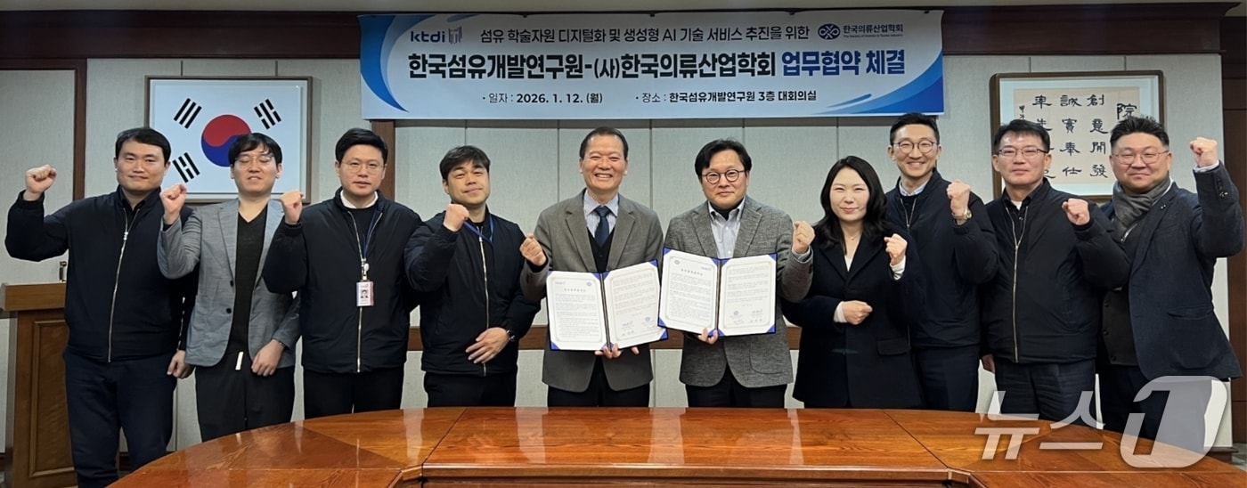 김성만 한국섬유개발연구원장(왼쪽 다섯번째)과 고준석 한국의류산업학회장(오른쪽 다섯번째)이 섬유 학술자원 디지털화와 생성형 인공지능(AI) 기술 서비스 고도화를 위한 업무협약을 체결한 뒤 직원들과 함께 파이팅을 외치고 있다.(섬유개발연구원 제공, 재판매 및 DB 금지)