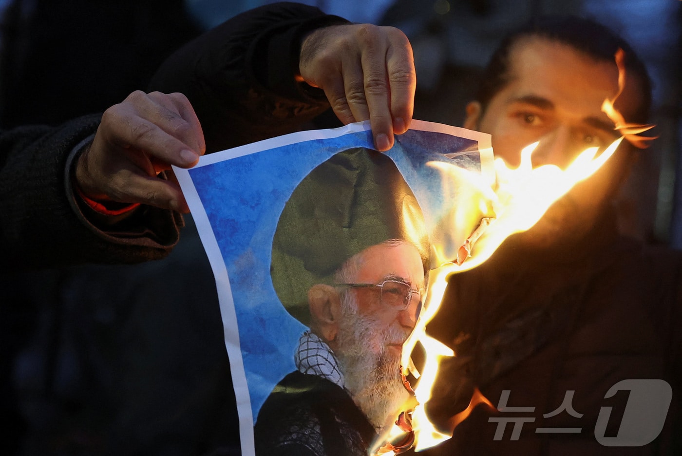 영국 런던에 모인 이란 반정부 시위대가 아야톨라 알리 하메네이 이란 최고지도자의 사진을 불태우고 있다. 2026.01.12 ⓒ 로이터=뉴스1 ⓒ News1 이지예 객원기자