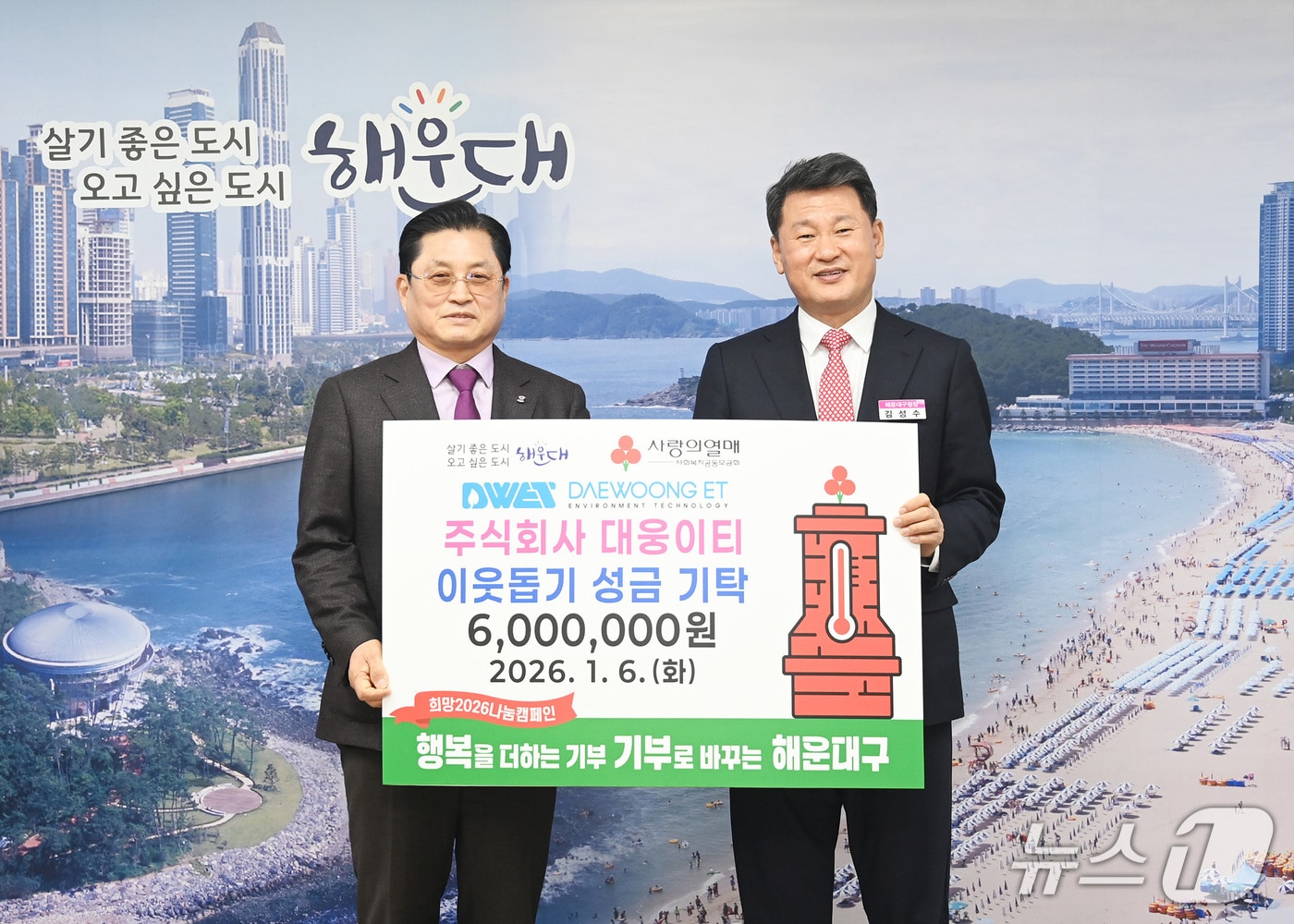 전희충 대웅이티 대표(왼쪽)이 김성수 부산 해운대구청장에게 이웃돕기 성금 600만 원을 기탁하고 있다.(해운대구 제공. 재판매 및 DB금지)