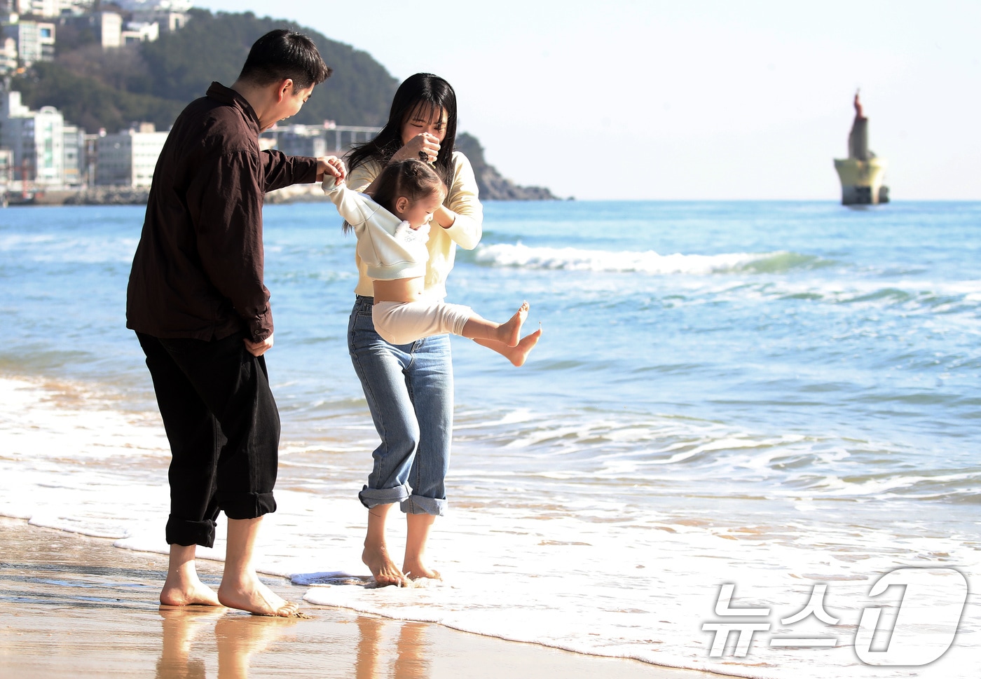 포근한 날씨를 보인 16일 부산 해운대해수욕장에서 가벼운 복장 차림을 한 가족이 바닷물에 발을 담그며 즐거운 시간을 보내고 있다. 2026.1.16/뉴스1 ⓒ News1 윤일지 기자