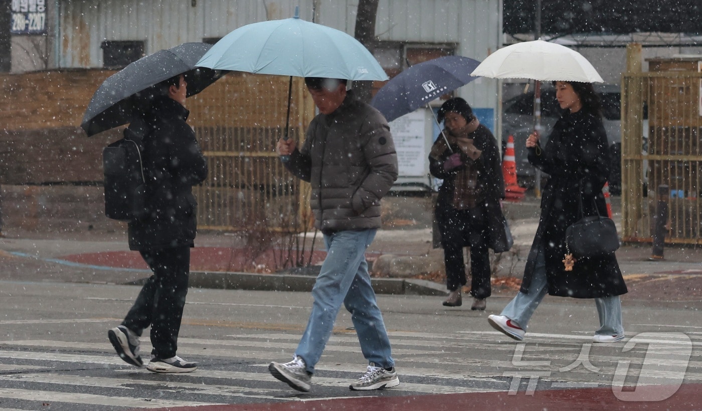 진눈깨비가 내린 지난 1월 19일 전북 전주시 기린대로에서 우산을 쓴 시민들이 발걸음을 옮기고 있다. ⓒ 뉴스1 유경석 기자