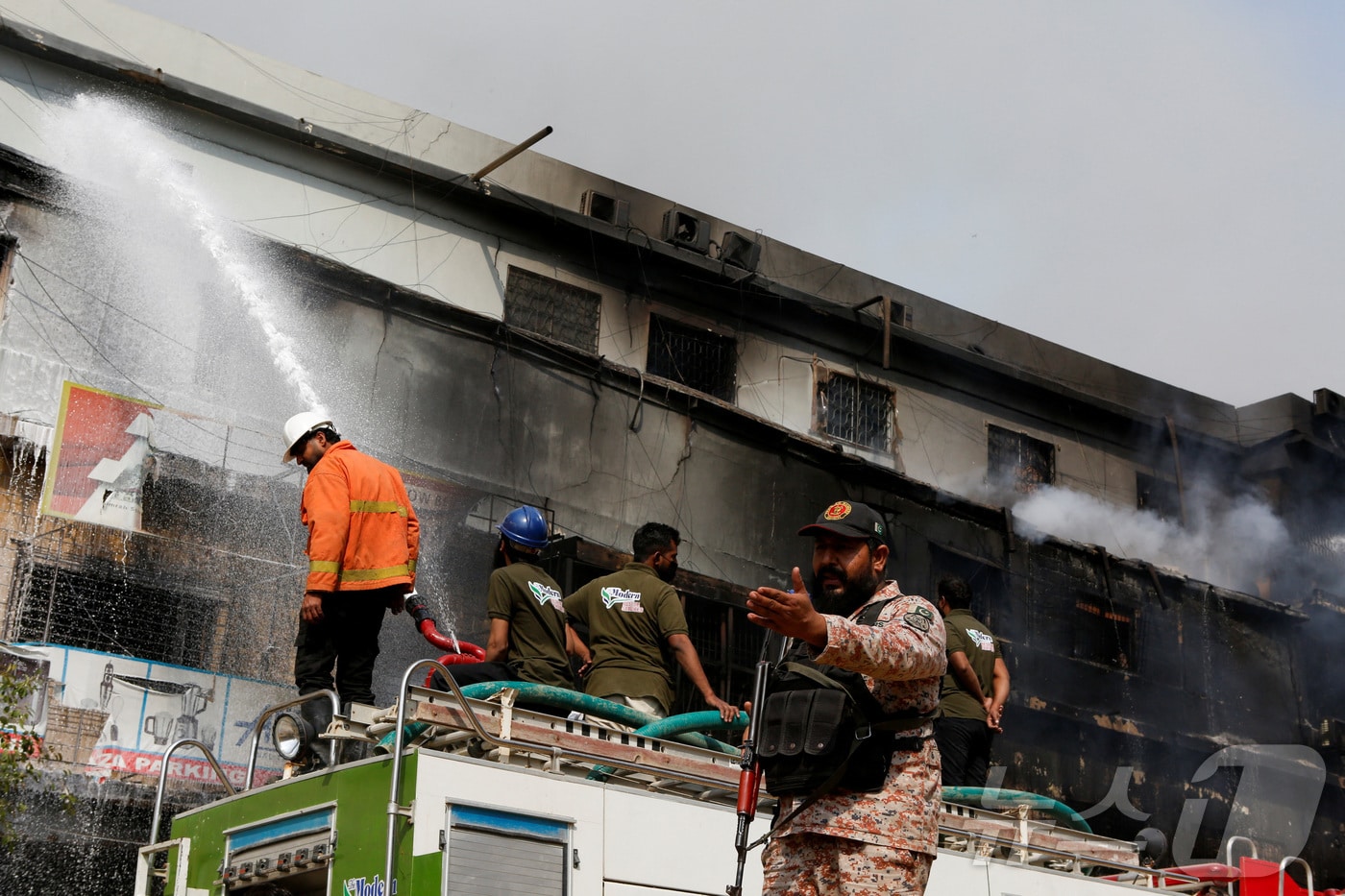 18일 파키스탄 카라치의 굴 플라자 쇼핑센터에서 발생한 대형 화재를 진압하기 위해 소방관들이 물을 뿌리고 있다.2026.01.18.ⓒ 로이터=뉴스1