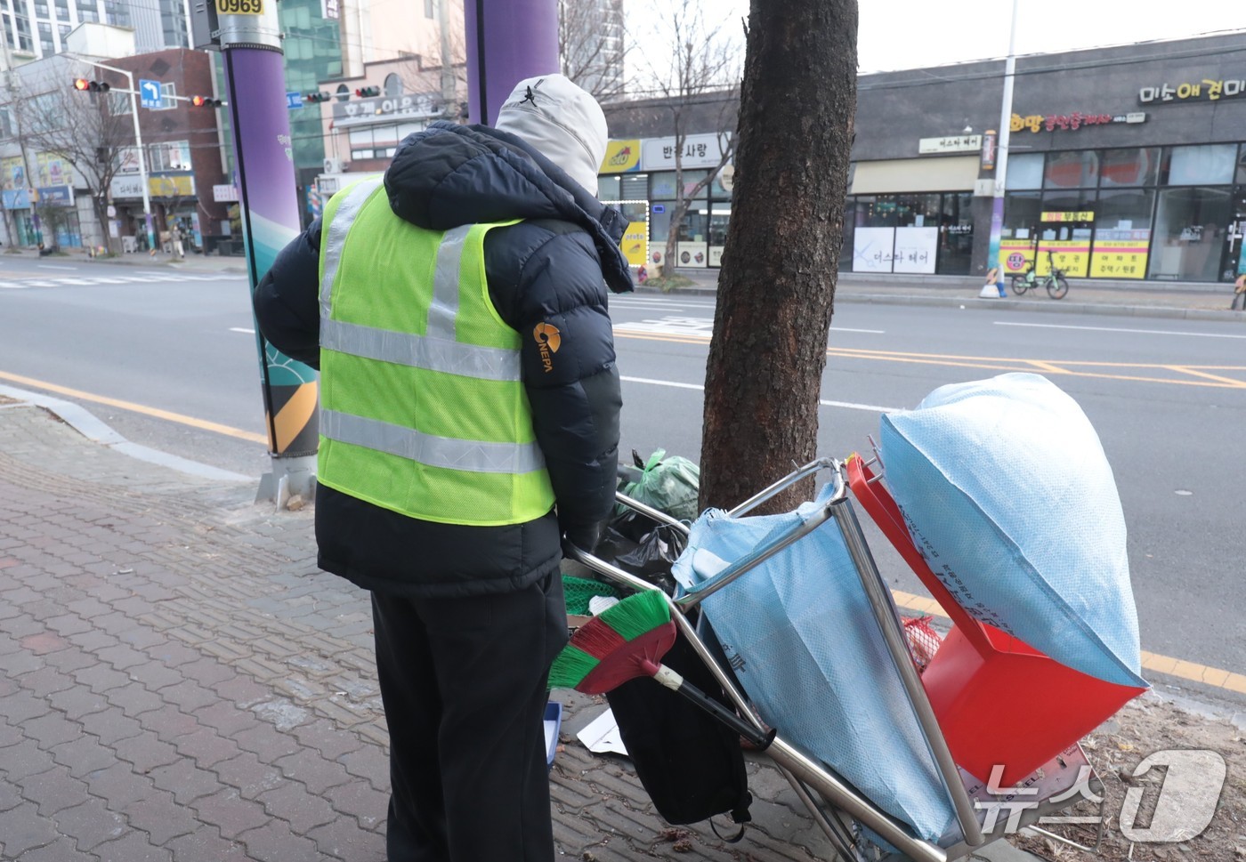 아침 영하권 기온을 보인 20일 울산의 한 거리에서 형광 조끼를 입은 환경 공무직 근로자가 쓰레기를 줍고 있다.2026.1.20./뉴스1 ⓒ News1 김세은 기자