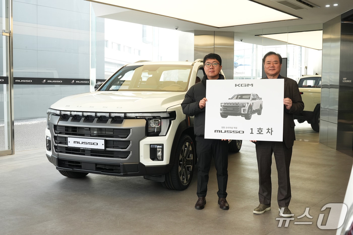지난 19일 KGM 익스피리언스 센터 일산에서 열린 ‘무쏘 1호차 전달식’에서 1호차 주인공 이미남 대표(왼쪽)와 권교원 사업부문장(오른쪽)이 기념 촬영을 하고 있다.(KGM 제공) 