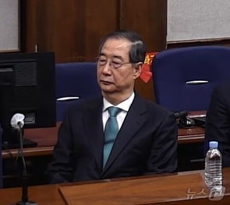 한덕수 전 국무총리가 21일 서울 서초구 서울중앙지방법원에서 열린 내란 우두머리 방조, 내란 중요임무 종사 혐의 사건 1심 선고공판에 출석해 자리에 앉아있다. (서울중앙지방법원 제공 영상 캡쳐. 재판매 및 DB 금지) 2026.1.21/뉴스1