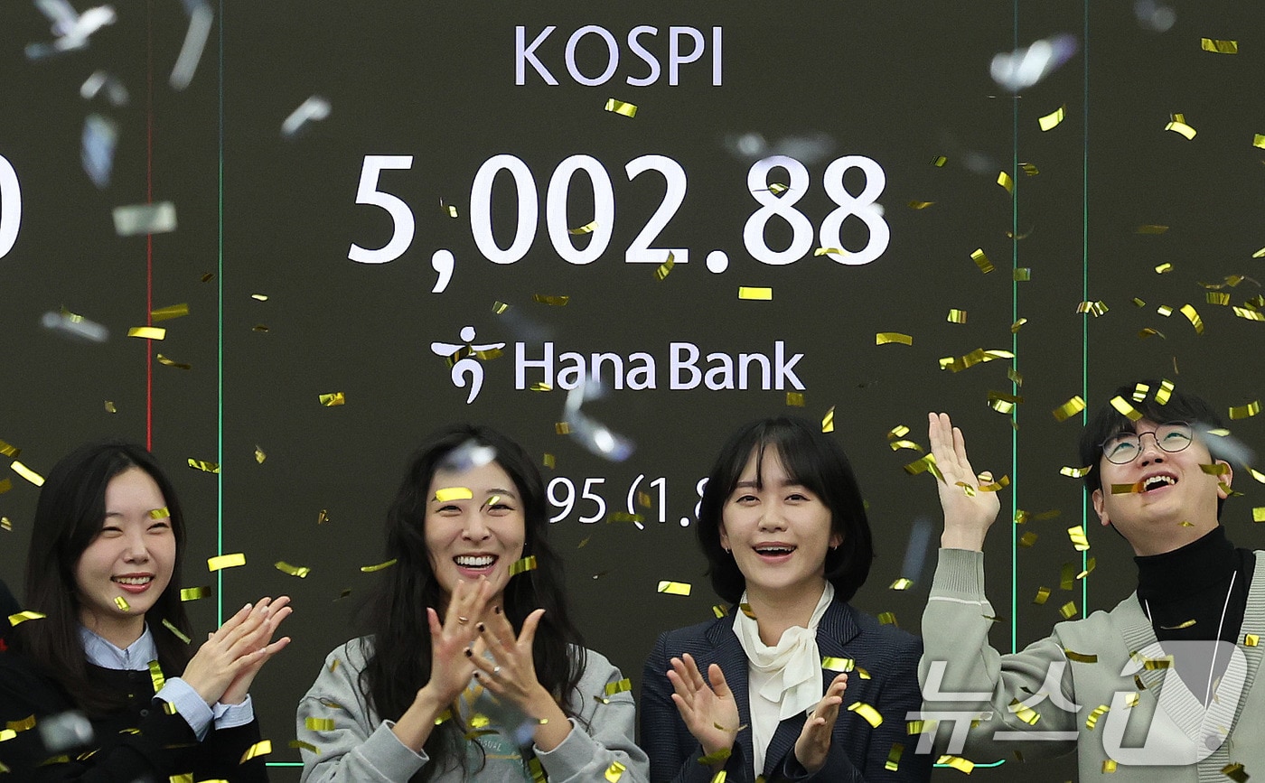 코스피지수가 사상 처음으로 장중 5000을 돌파한 22일 오전 서울 을지로 하나은행 딜링룸에서 직원들이 신기록 달성을 축하하고 있다. 이날 코스피지수는 한때 5019.54까지 상승했다가 0.87% 오른 4952.53에 거래를 마쳤다. 2026.1.22/뉴스1 ⓒ News1 박지혜 기자