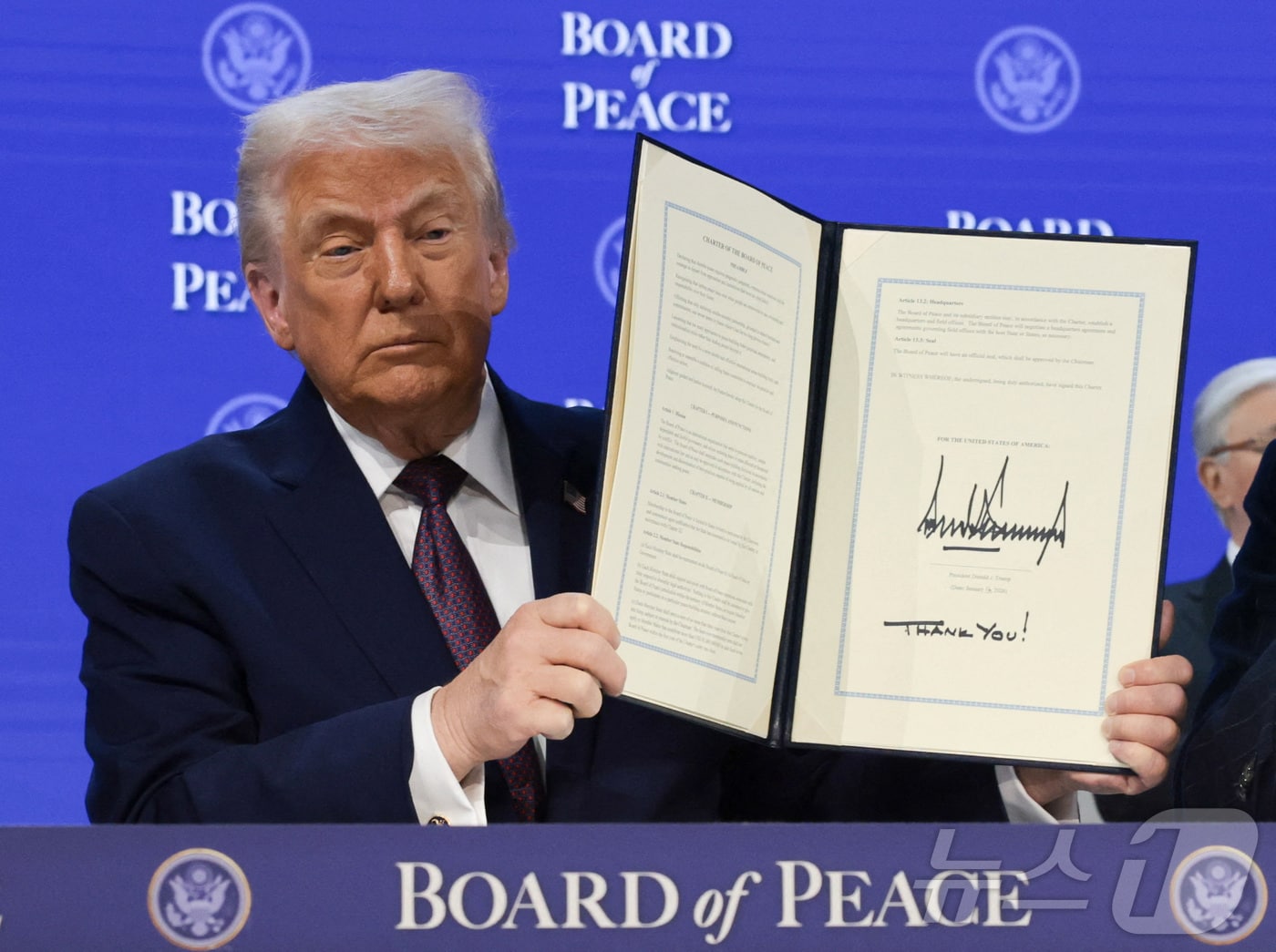 평화위원회 헌장에 서명한 뒤 들어보이는 트럼프 미국 대통령. 2026.01.22 ⓒ 로이터=뉴스1 ⓒ News1 이지예 객원기자