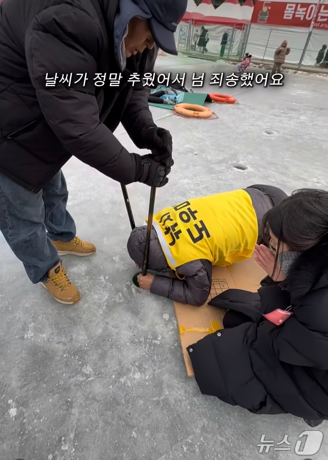 관광객이 화천 산천어를 잡고 기뻐하다 낚시 구멍에 휴대폰을 빠뜨린 가운데 '낚시 도우미'가 휴대폰을 건지기 위해 노력을 하고 있다.(A 씨 SNS 캡처, 재판매 및 DB금지)