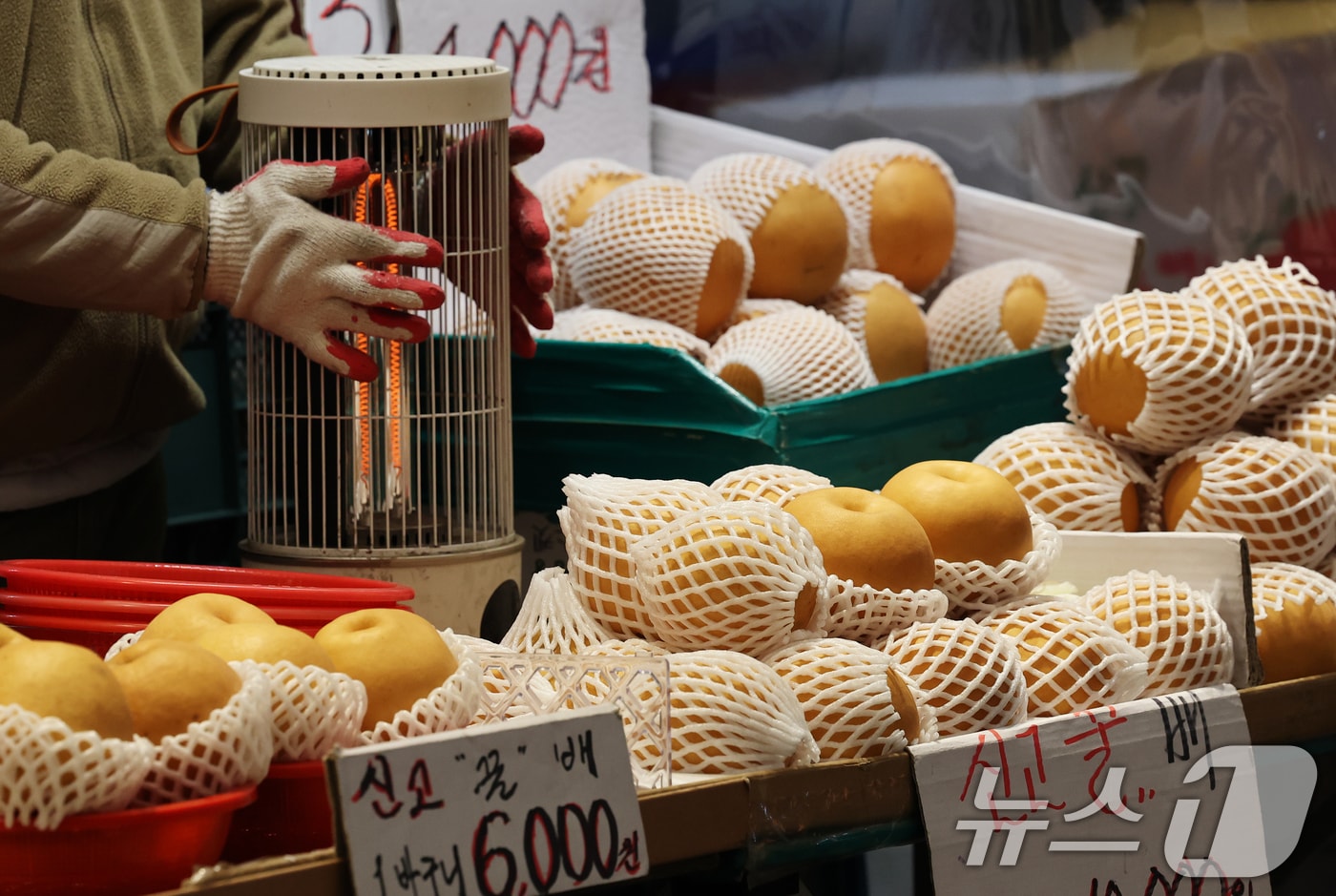  28일 오전 서울 동대문구의 한 전통시장에서 과일가게 상인이 언 손을 녹이고 있다. 2026.1.28/뉴스1 ⓒ News1 오대일 기자