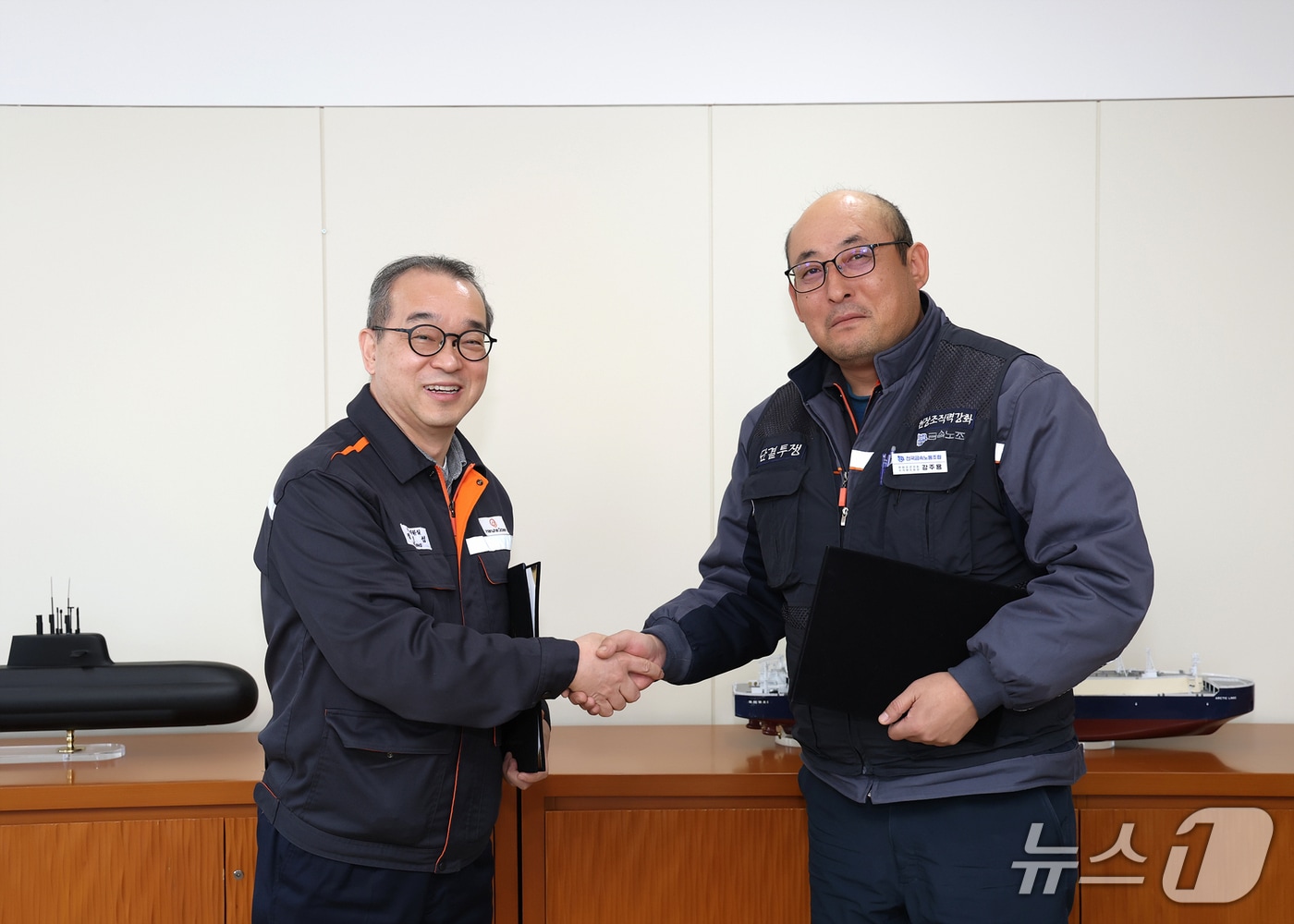 (왼쪽부터)한화오션 경영지원실장 정인섭 사장과 한화오션지회 강주용 수석부지회장이 발전적인 노사관계 구축을 위한 합의서에 서명한 뒤 악수하고 있다.(한화오션 제공. 재판매 및 DB금지)