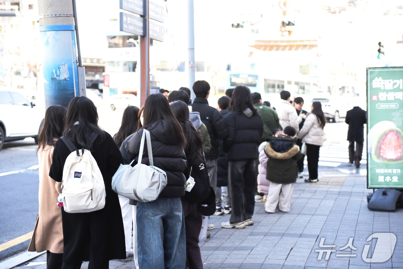 31일 추위가 누그러진 가운데 전남 여수를 방문한 관광객들이 한 상점앞에 줄을 서 있다. 뉴스1