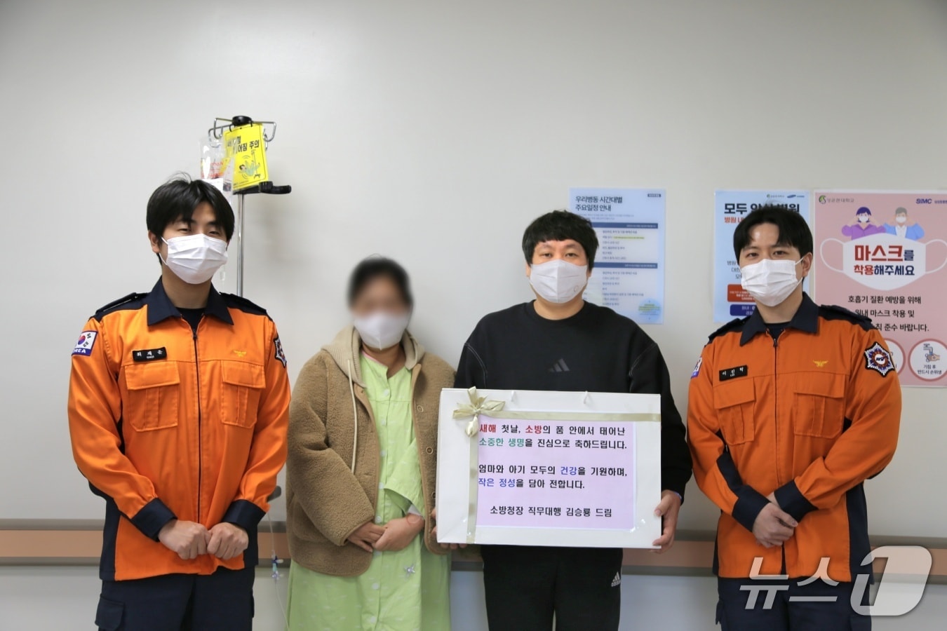 소방헬기 안에서 태어난 새 생명에게 소방공무원들의 마음을 담아 '새해 첫 특별선물'을 전달하고 있다.(소방청 제공)