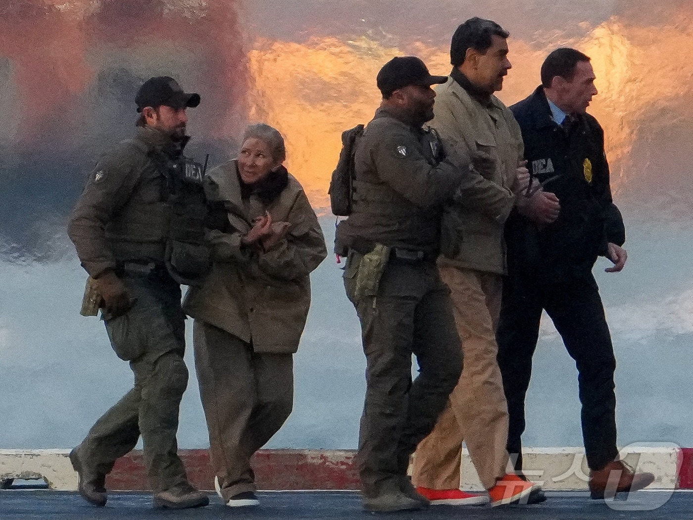 미국 마약단속국(DEA) 요원들이 체포된 니콜라스 마두로 베네수엘라 대통령과 부인 실리아 플로레스를 헬리콥터에서 내리게 하고 있다. 2026.01.05. ⓒ 로이터=뉴스1 ⓒ News1 이정환 기자