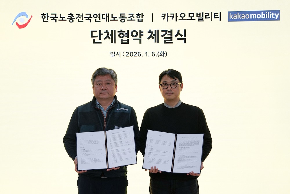 6일 경기 성남시 카카오모빌리티 사옥에서 진행된 단체협약 체결식에서 김태현 카카오모빌리티 에이전트 사업실 상무(오른쪽)와 이상국 플랫폼운전자노동조합 위원장이 협약 체결 후 기념사진을 촬영하고 있다. (카카오모빌리티 제공)