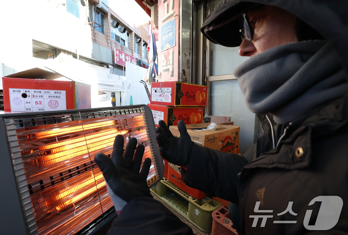 경기 수원시 팔달구 영동시장에서 상인들이 전기난로에 몸을 녹이고 있다. 2026.1.8/뉴스1 ⓒ News1 김영운 기자