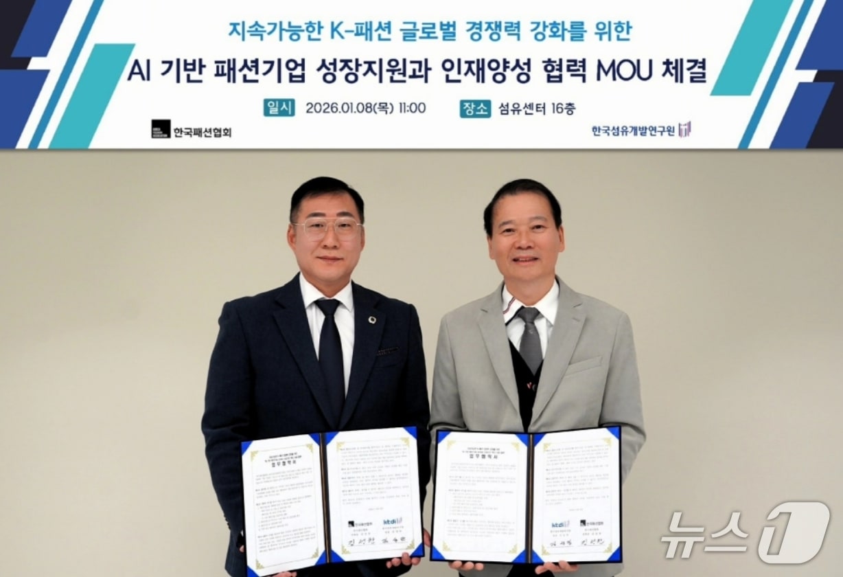 김성만 한국섬유개발연구원장(오른쪽)과 김성찬 한국패션협회 부회장이 '인공지능(AI) 기반 패션기업 성장과 산업구조 혁신 지원 협력'을 위한 업무협약을 체결한 후 협약서를 펼쳐 보이고 있다.(섬유개발연구원 제공, 재판매 및 DB 금지)